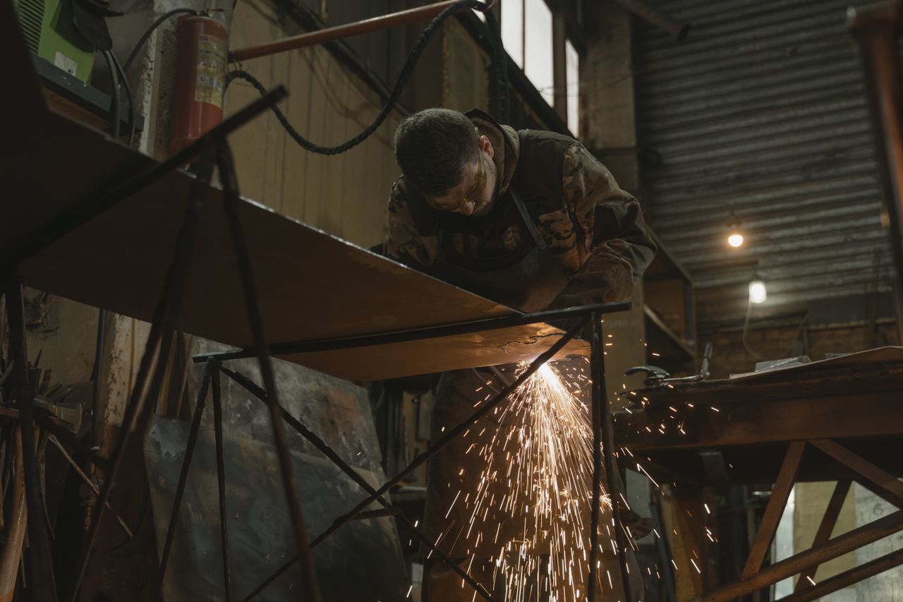 The Art of Drawing Readers In: Your attractive post title goes here A worker focused on welding metal inside an industrial setting with sparks flying.